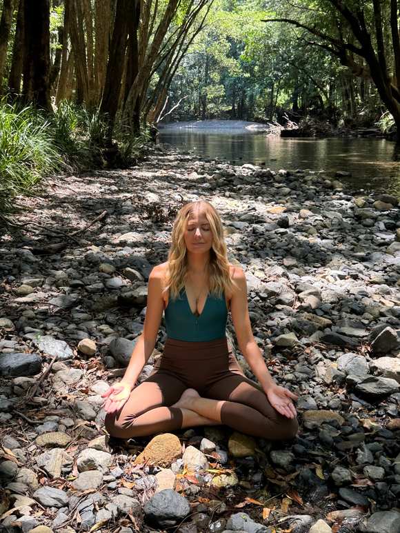 Meditating by a rainforest creek