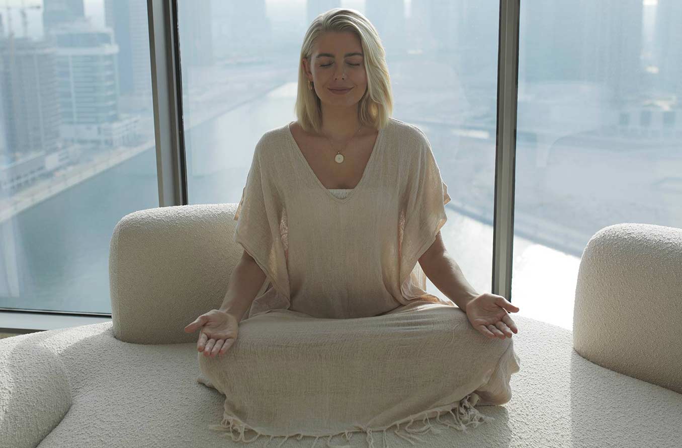 Person meditating on a rooftop overlooking a city